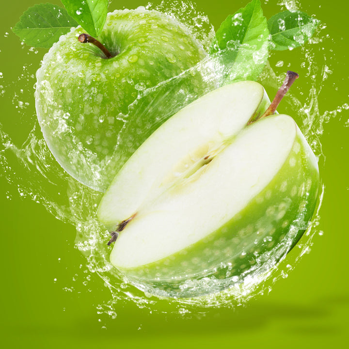 Crisp juicy green apple cut in half splashing in water